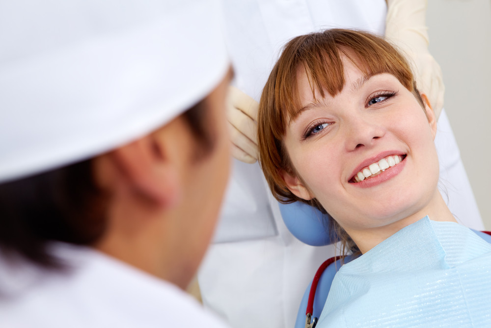 Image of smiling patient looking at the dentist